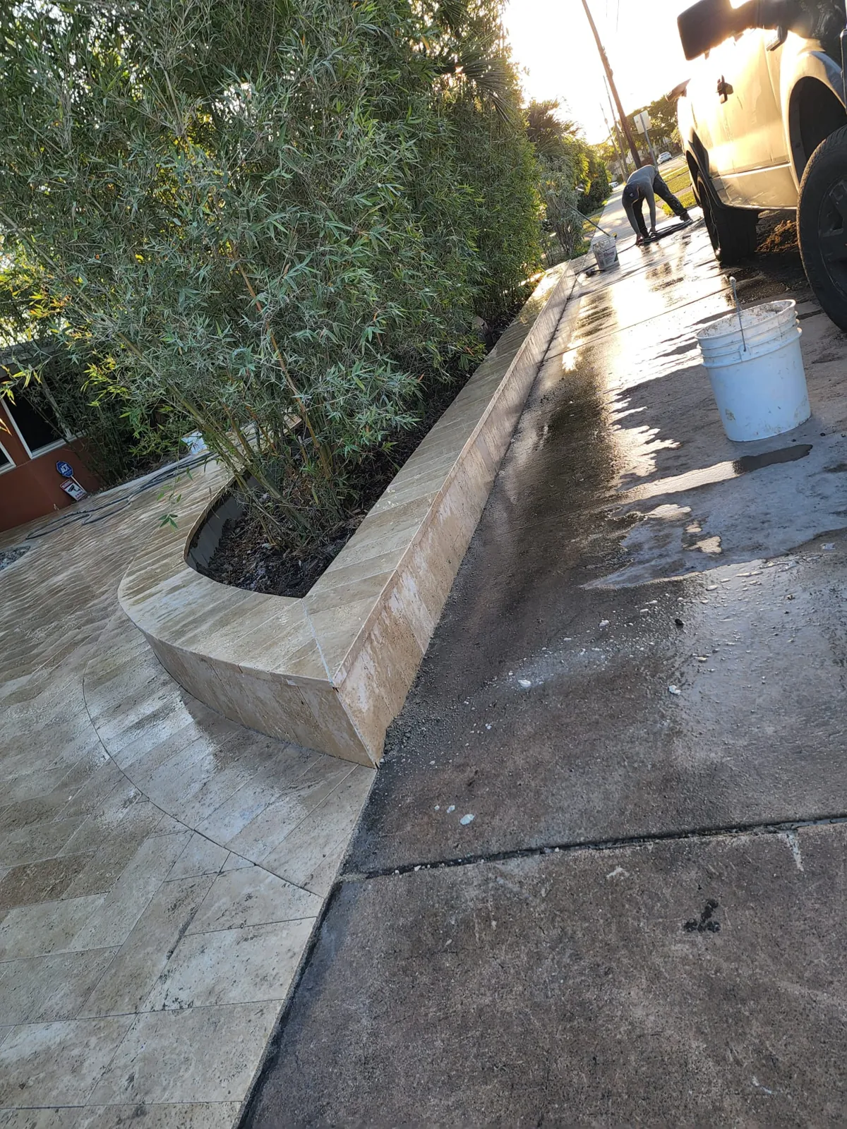 Raised stone planter edge beside a paved path
